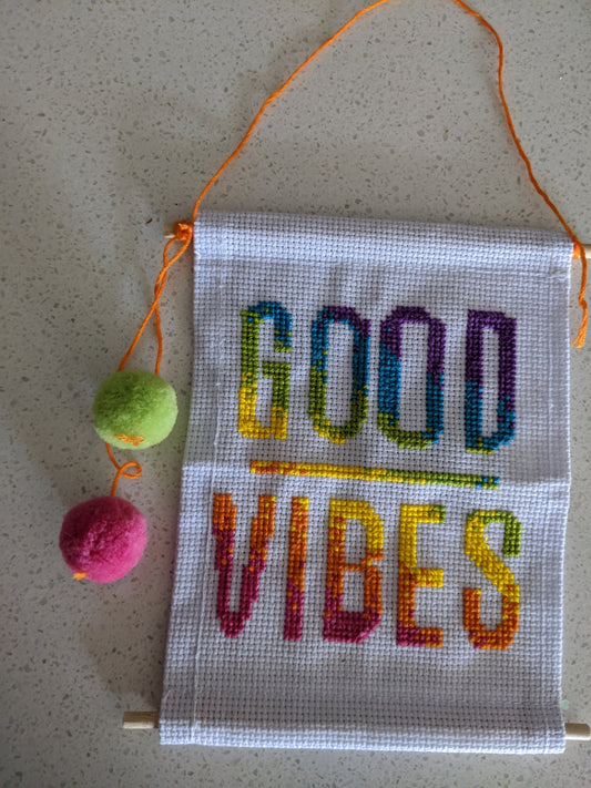 Handmade cross stitched good vibes wall hanging.